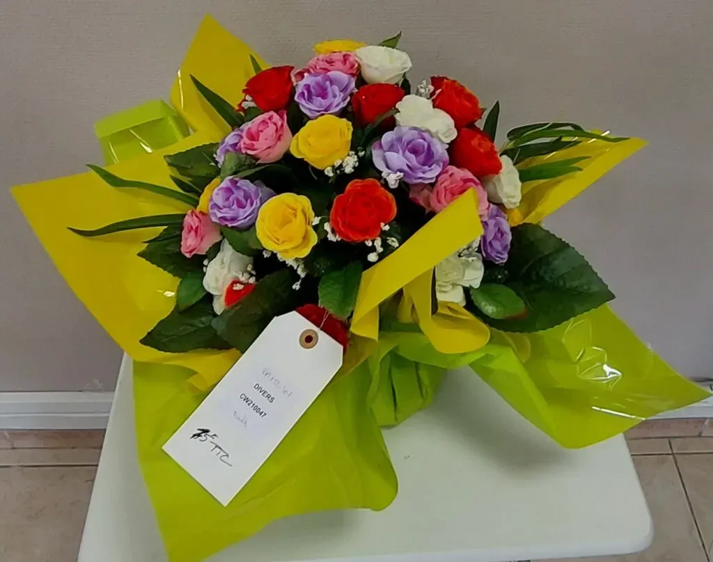 Bouquet de fleurs artificielles variées dans un emballage cadeau.