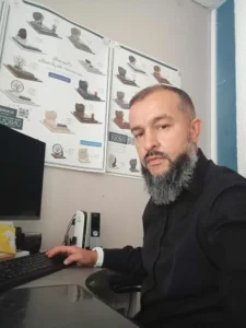 Conseiller funéraire au bureau travaillant sur ordinateur devant des affiches de monuments.