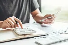 Calcul et organisation du budget d'obsèques avec une calculatrice et des factures.