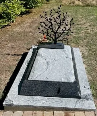 Tombe moderne bicolore avec un mémorial Arbre de vie noir sur socle.