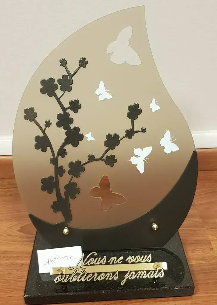 Plaque funéraire moderne gravée avec papillons et branche de fleurs.