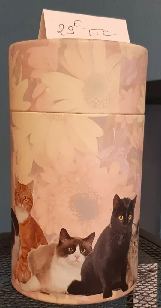 Urne funéraire pour chat illustrée de félins sur fond floral.